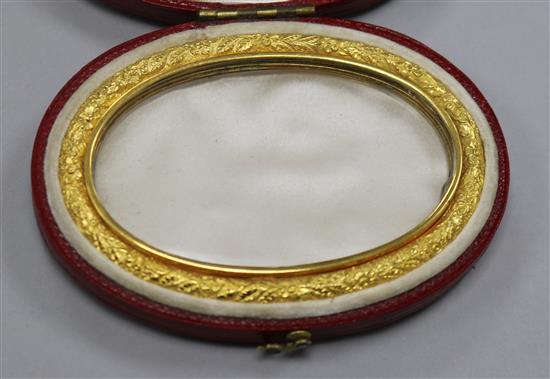 A 19th century gold mounted glazed oval miniature frame in fitted red leather case, 75mm.